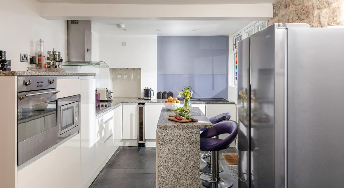 The sleek kitchen has modern amenities, including a larger American-style fridge freezer.