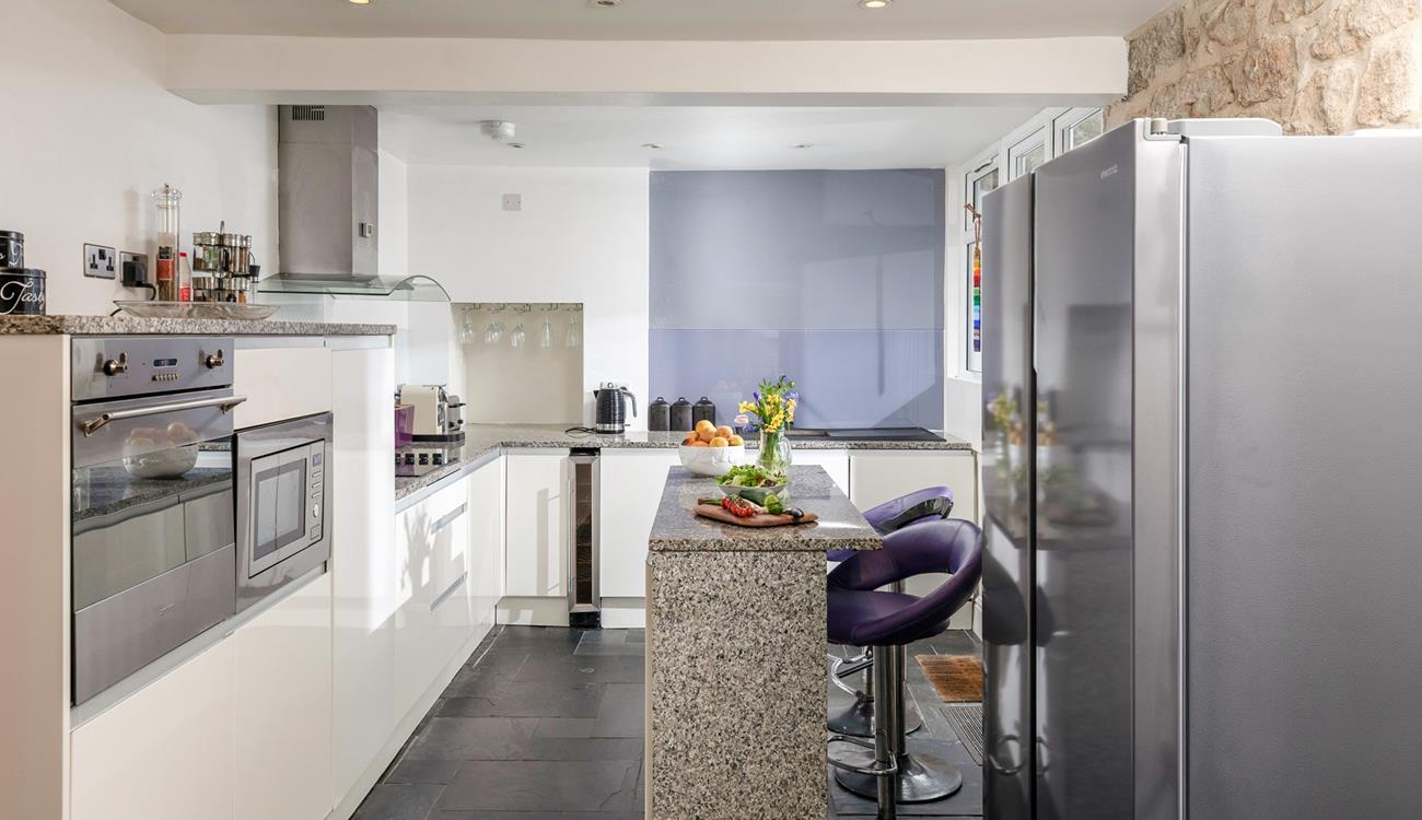 The sleek kitchen has modern amenities, including a larger American-style fridge freezer.