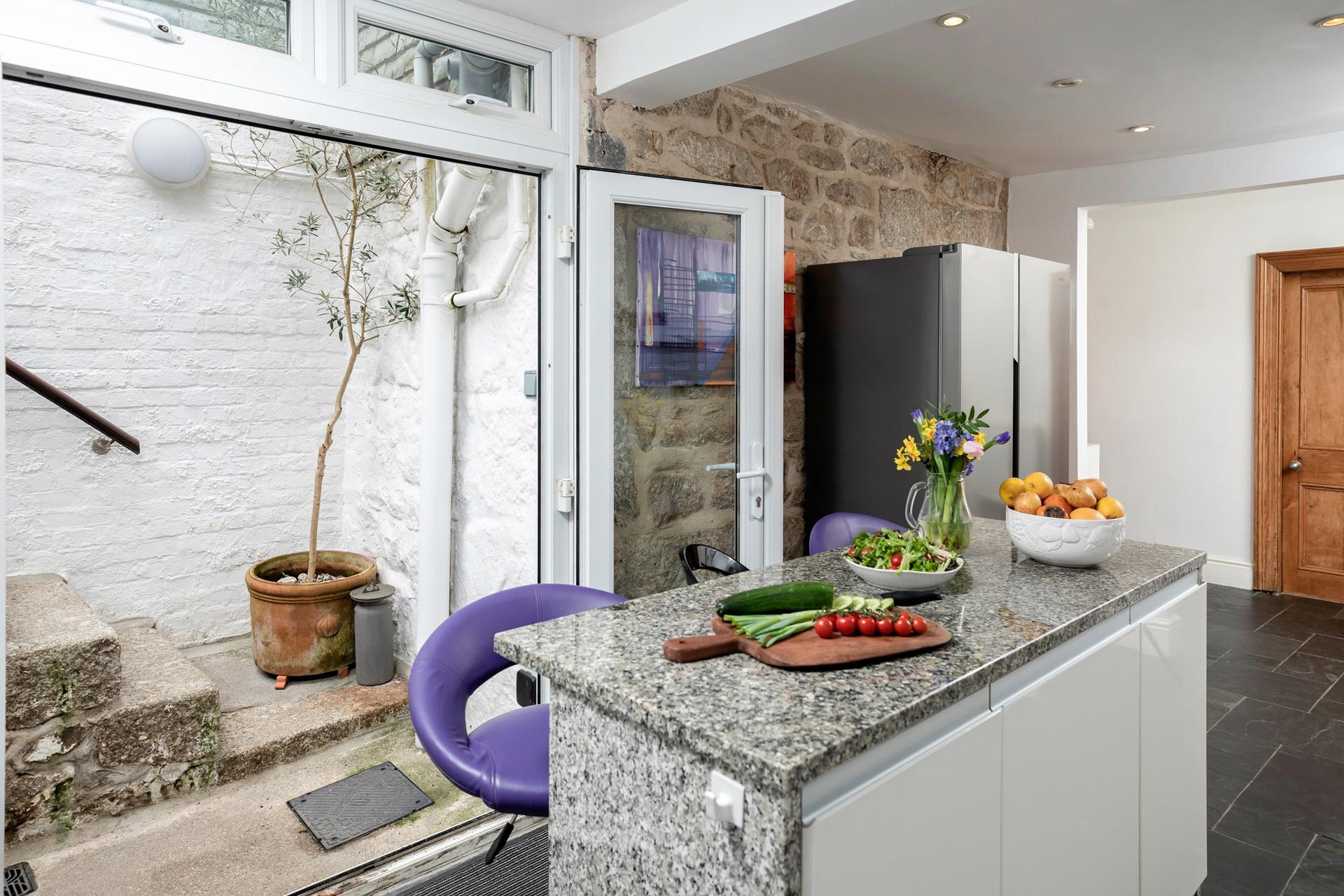 Steps from the kitchen take you out and up to the leafy garden.