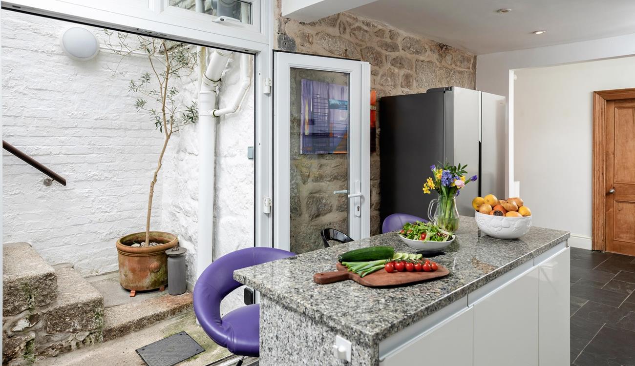 Steps from the kitchen take you out and up to the leafy garden.