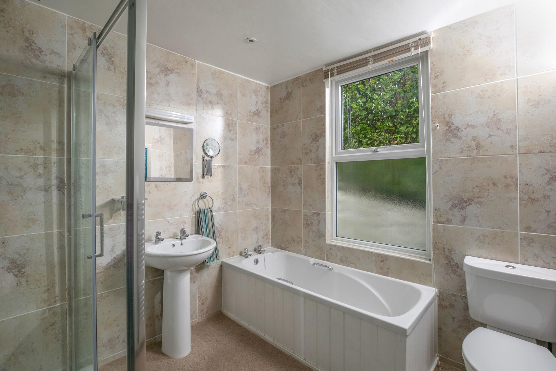 The family bathroom has a walk-in shower and bath. 