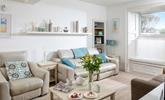 The sitting room is decorated with calming tones of coastal blue. - Thumbnail Image