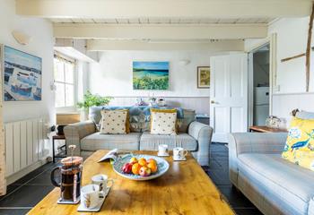 The cosy sitting room is filled with colourful Cornish artwork.