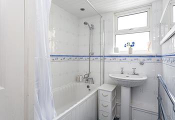 The bathroom has a charming cottage feel and benefits from a bath and shower.