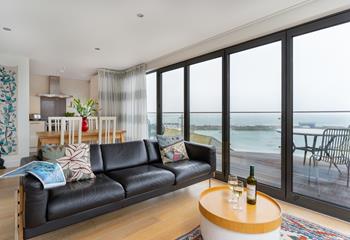The living area features large bifold doors that open out onto the expansive balcony. 