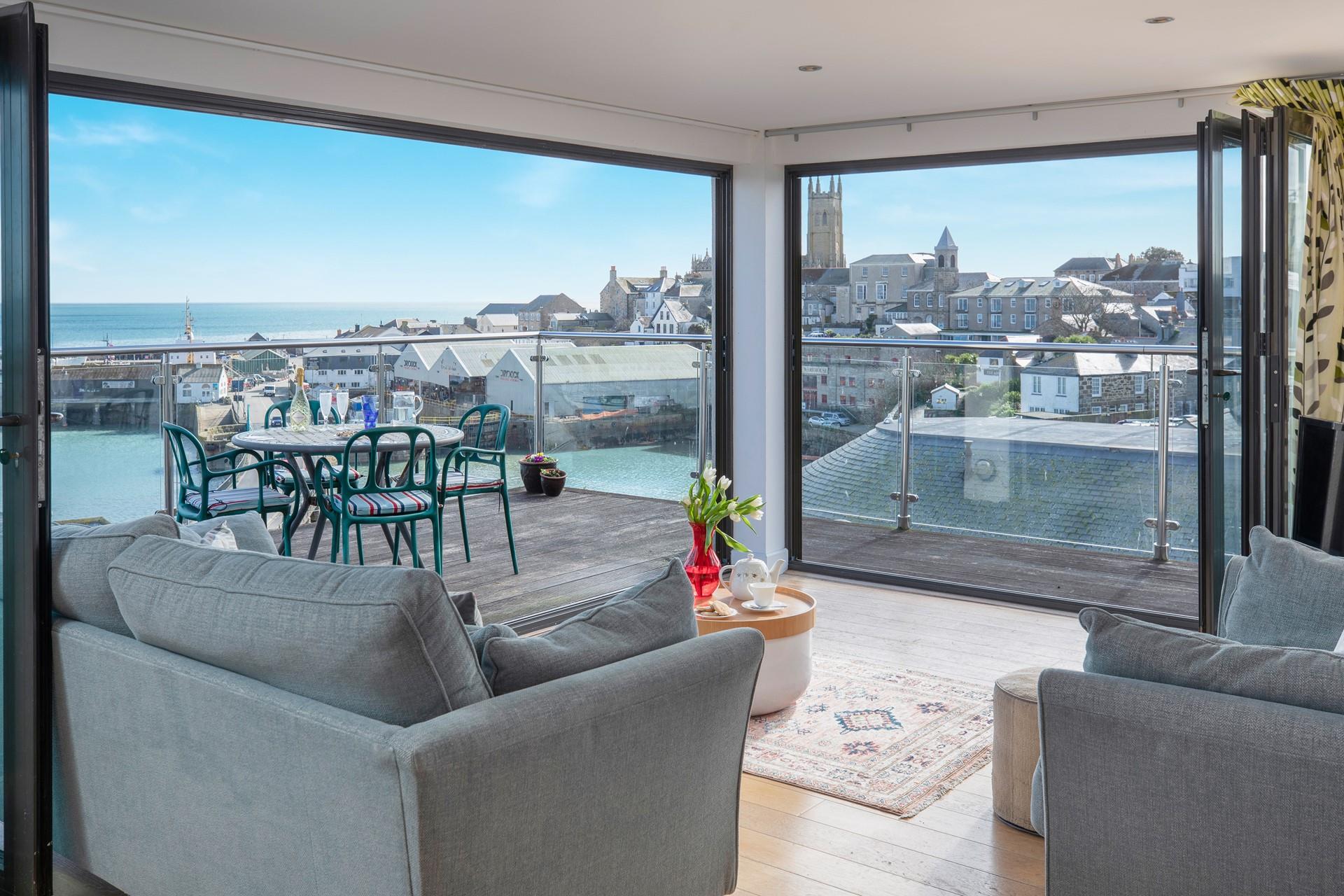 The living area features large bifold doors that open onto the expansive balcony.