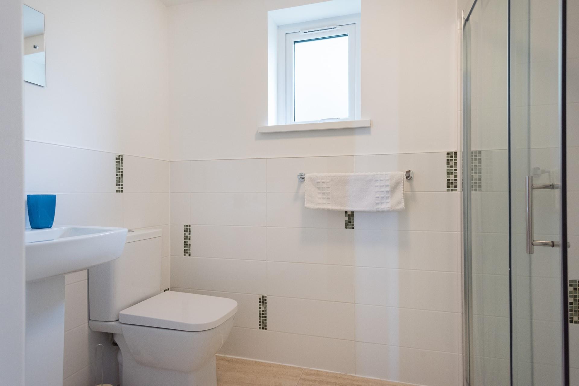 The main shower room is bright and spacious with an enclosed shower. 