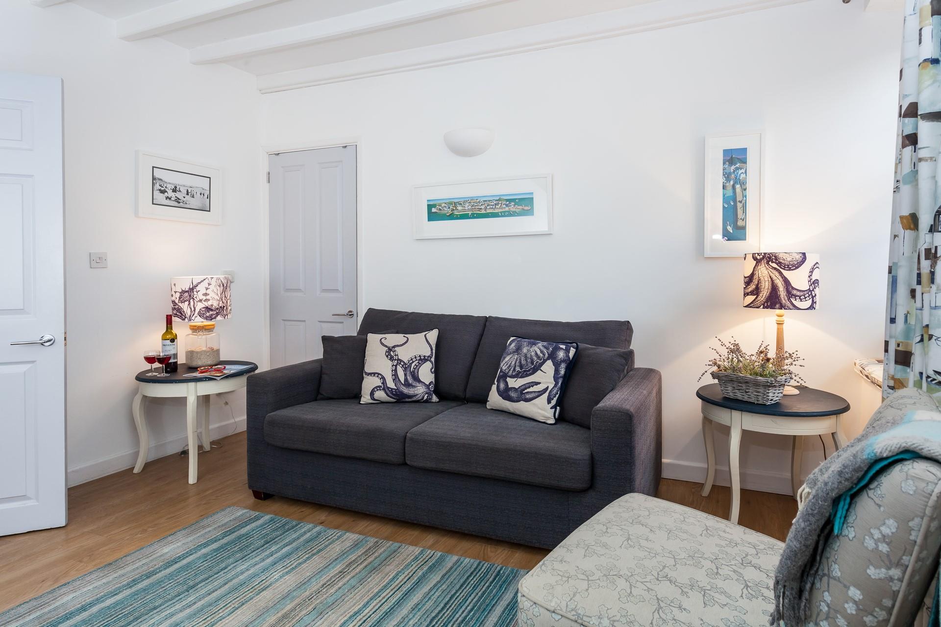 The sitting room is bright and airy with stunning nautical art that nods to St Ives' rich artistic history.