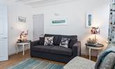 The sitting room is bright and airy with stunning nautical art that nods to St Ives' rich artistic history. - Thumbnail Image