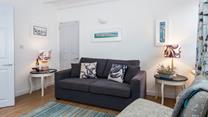 The sitting room is bright and airy with stunning nautical art that nods to St Ives' rich artistic history.