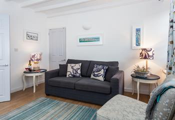 The sitting room is bright and airy with stunning nautical art that nods to St Ives' rich artistic history.