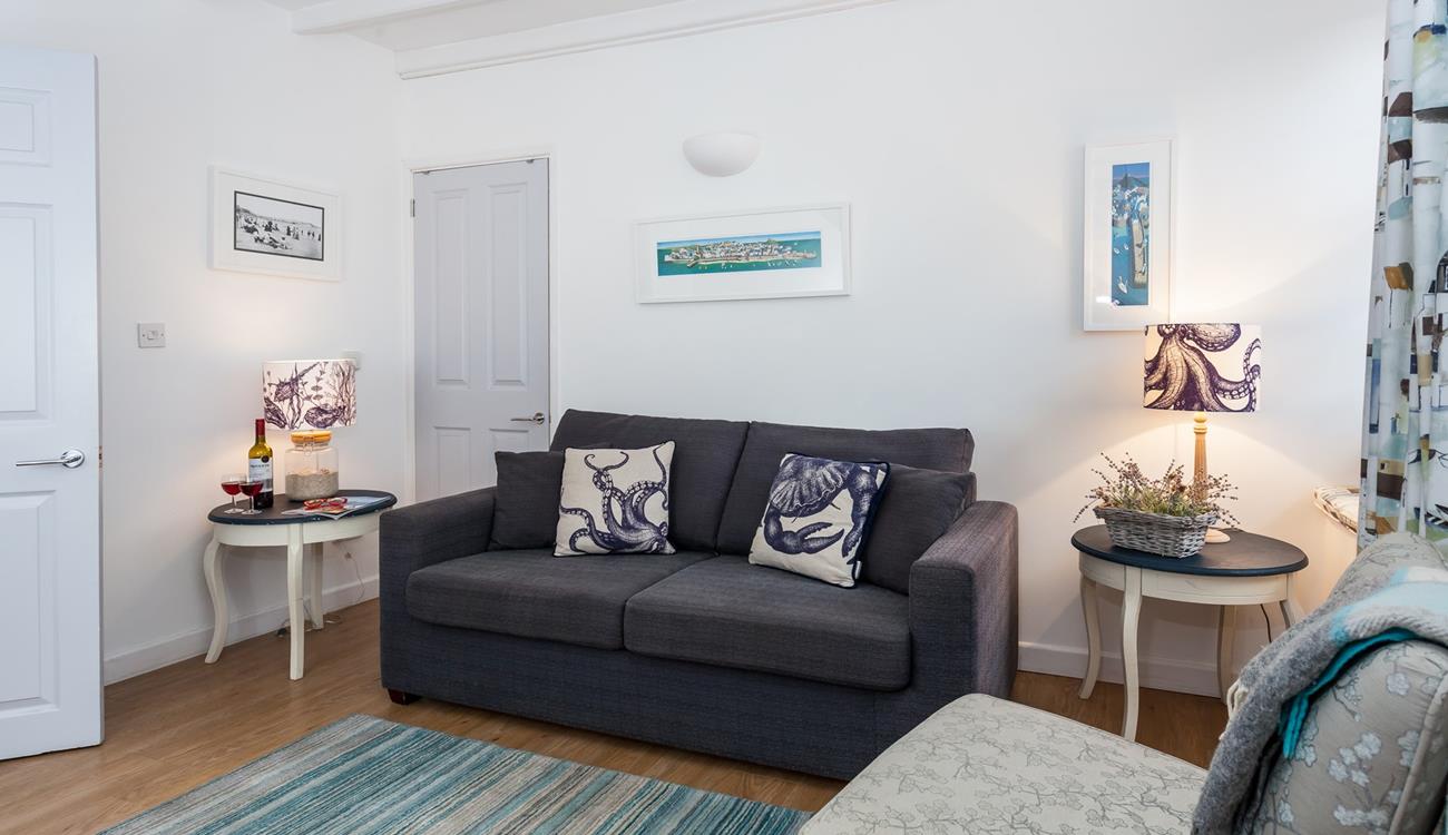 The sitting room is bright and airy with stunning nautical art that nods to St Ives' rich artistic history.