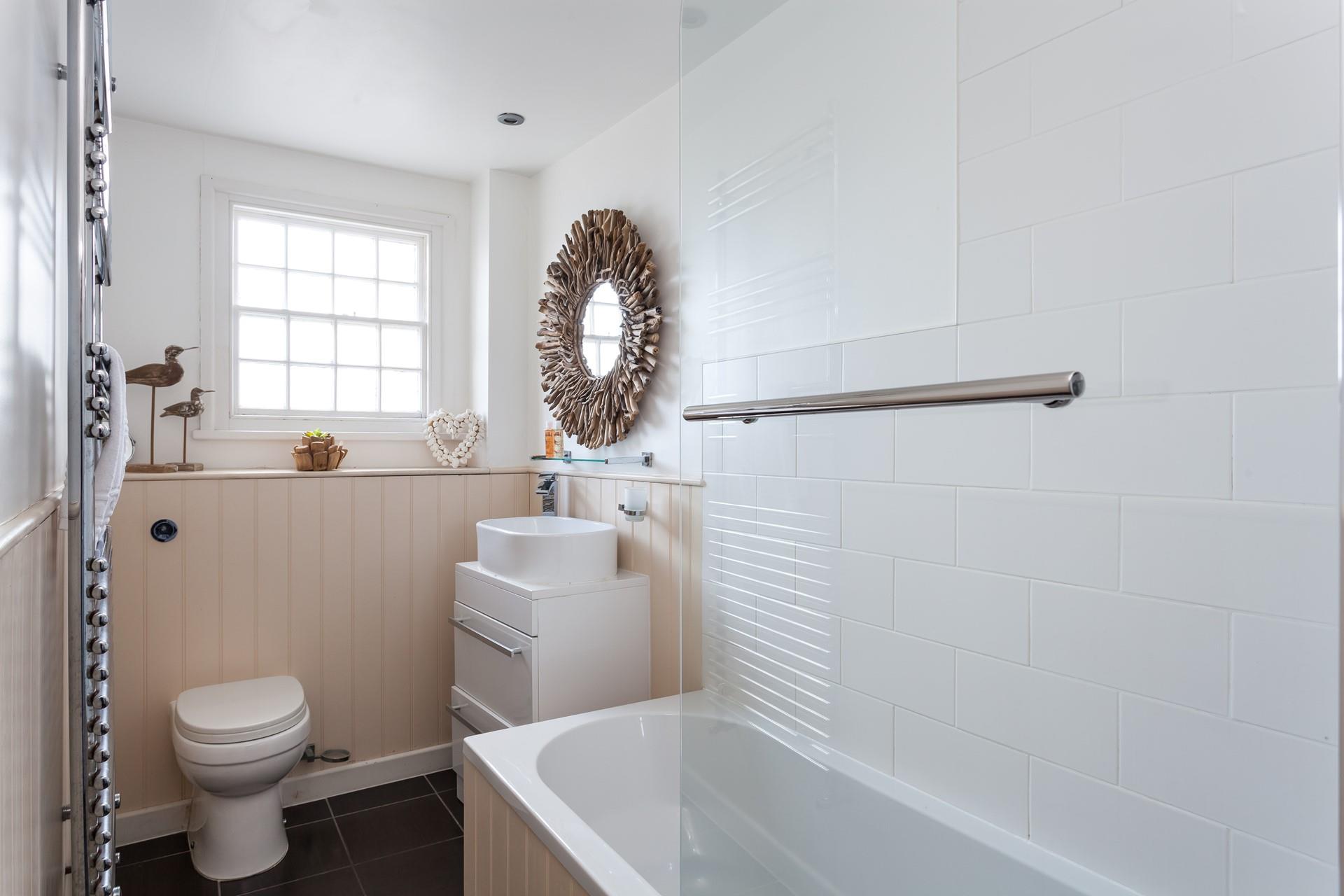 The stylish bathroom benefits from a bath with a shower.