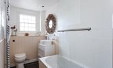 The stylish bathroom benefits from a bath with a shower. - Thumbnail Image