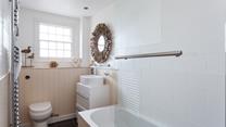 The stylish bathroom benefits from a bath with a shower.