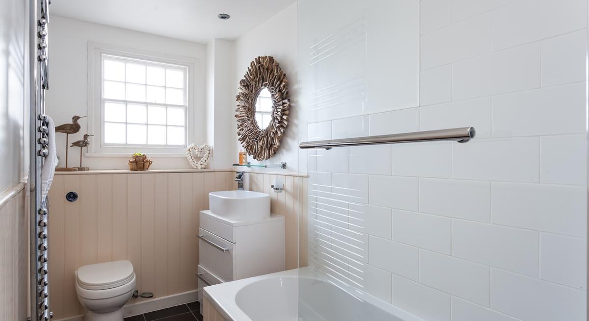 The stylish bathroom benefits from a bath with a shower.