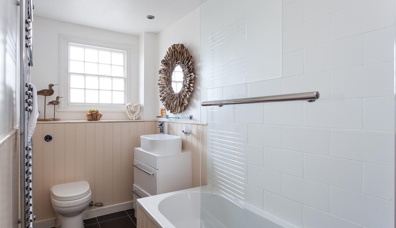 The stylish bathroom benefits from a bath with a shower.