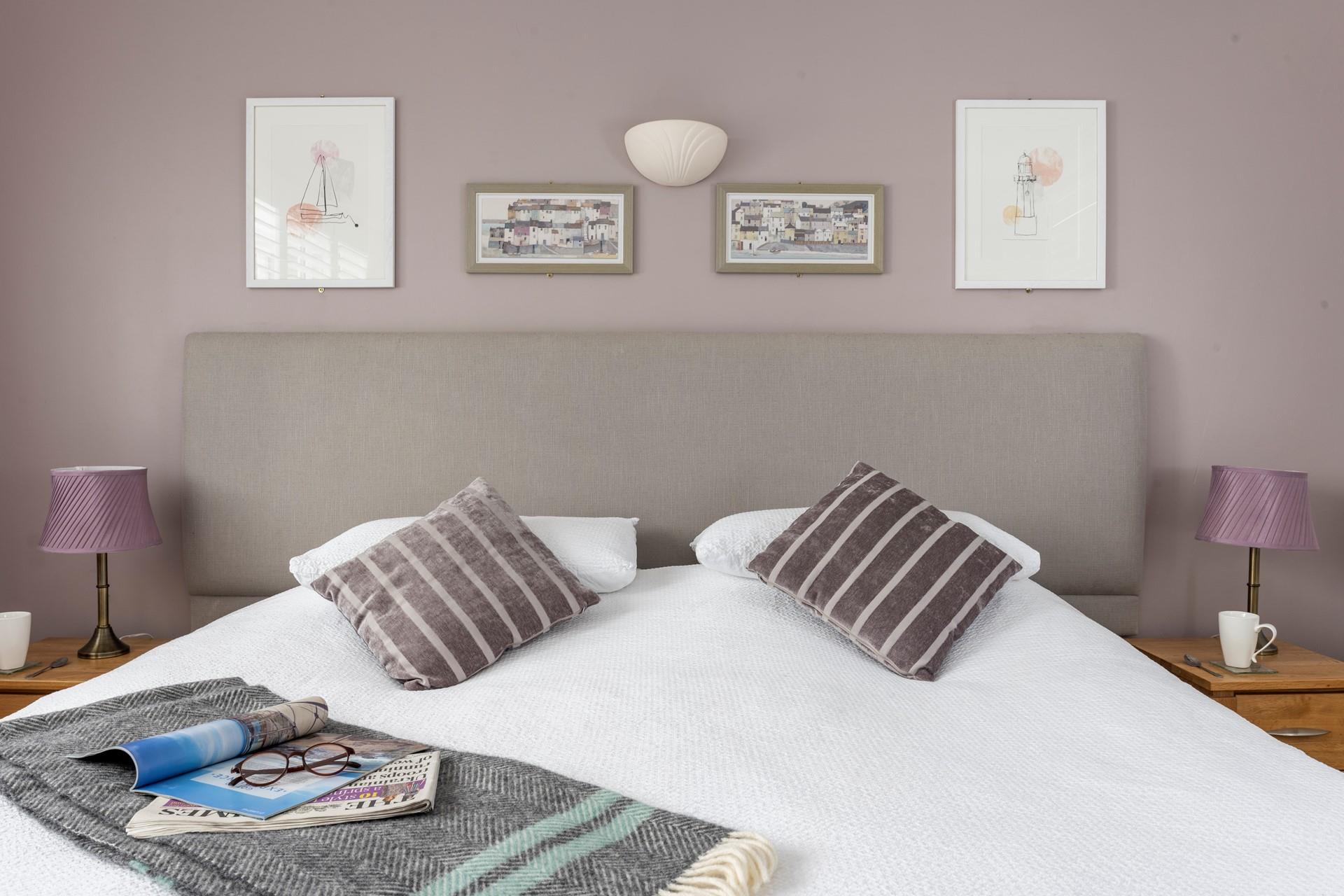 Fresh white linen and soft cushions create the perfect space for a restful night's sleep. 