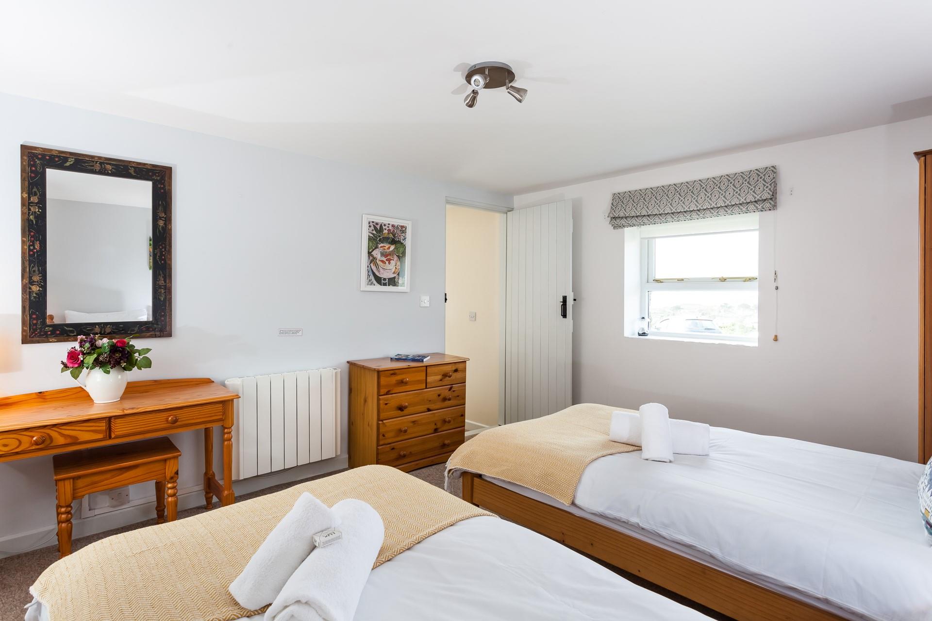 Soft sheets and fluffy towels await in this comfortable bedroom.