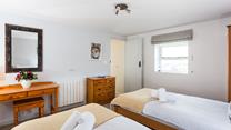 Soft sheets and fluffy towels await in this comfortable bedroom.