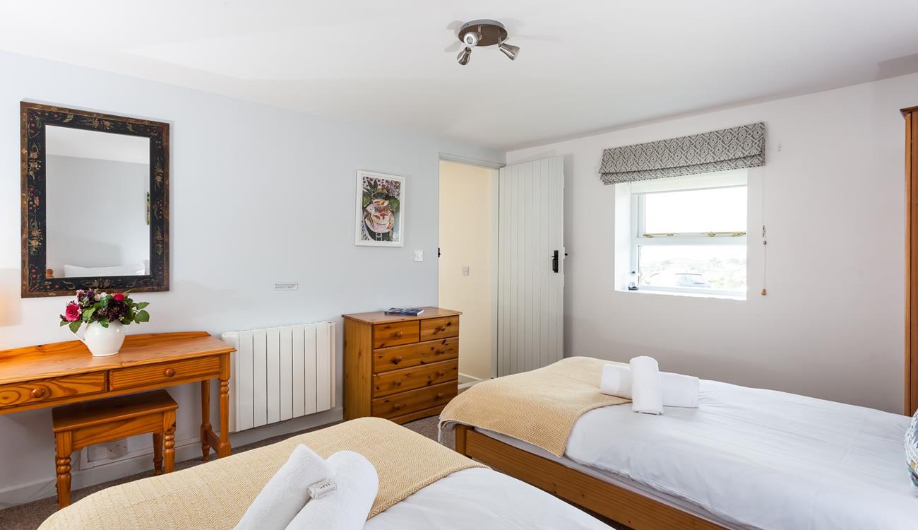 Soft sheets and fluffy towels await in this comfortable bedroom.