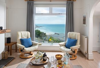 A stunning view over St Ives Bay from the sitting room area, enjoy relaxing in the recliner chairs with a cold G&T.