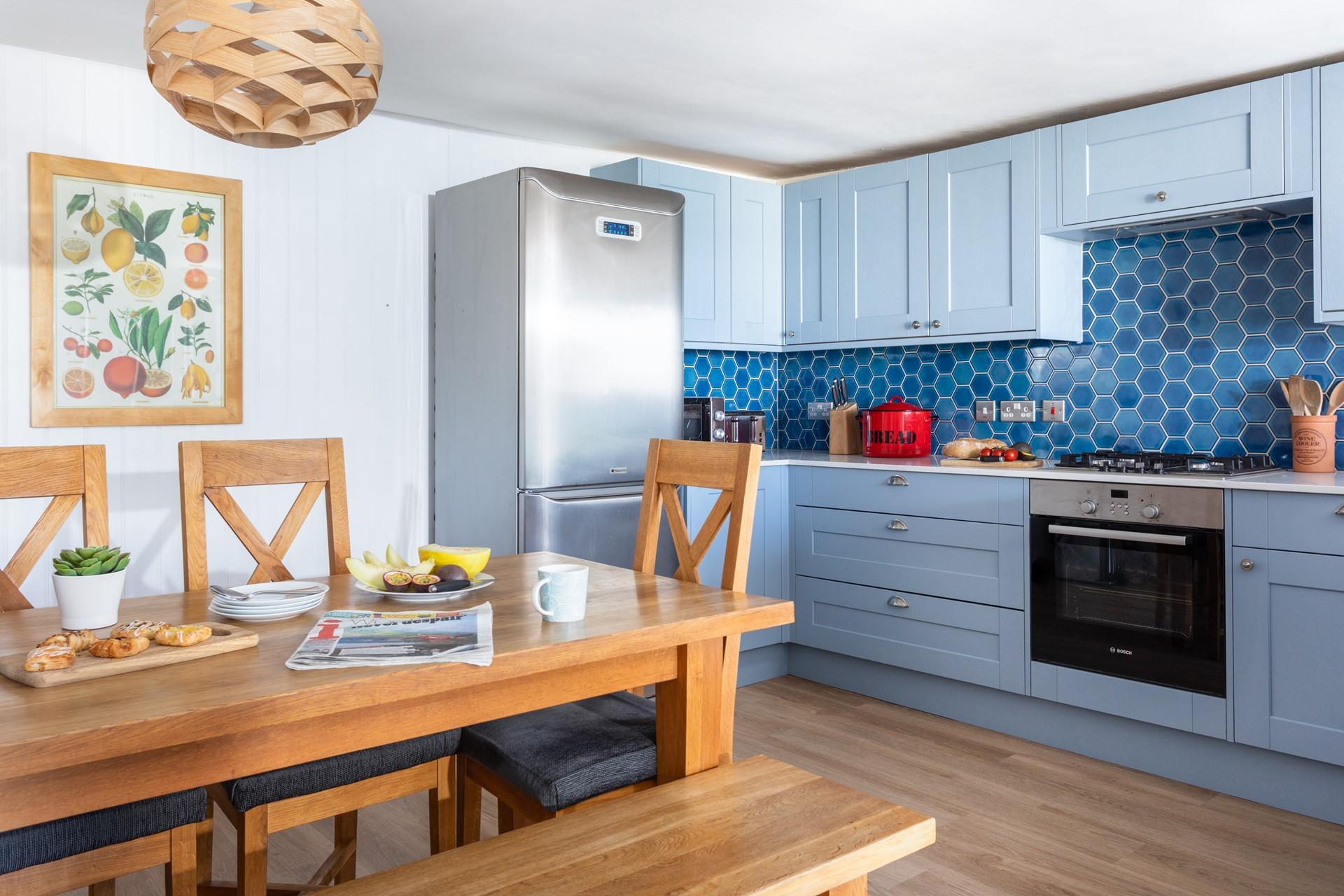 The kitchen is well-equipped with an ocean blue theme.