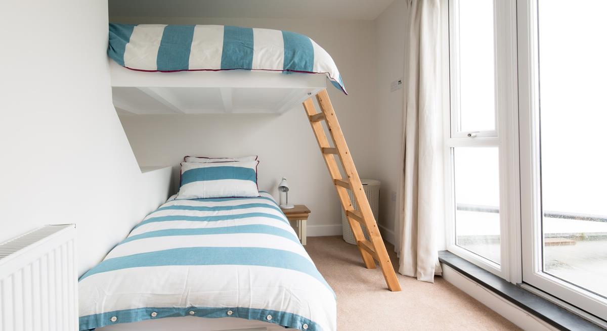 This cleverly-designed bedroom features a single bed below with a double bed above, integrated into the wall.