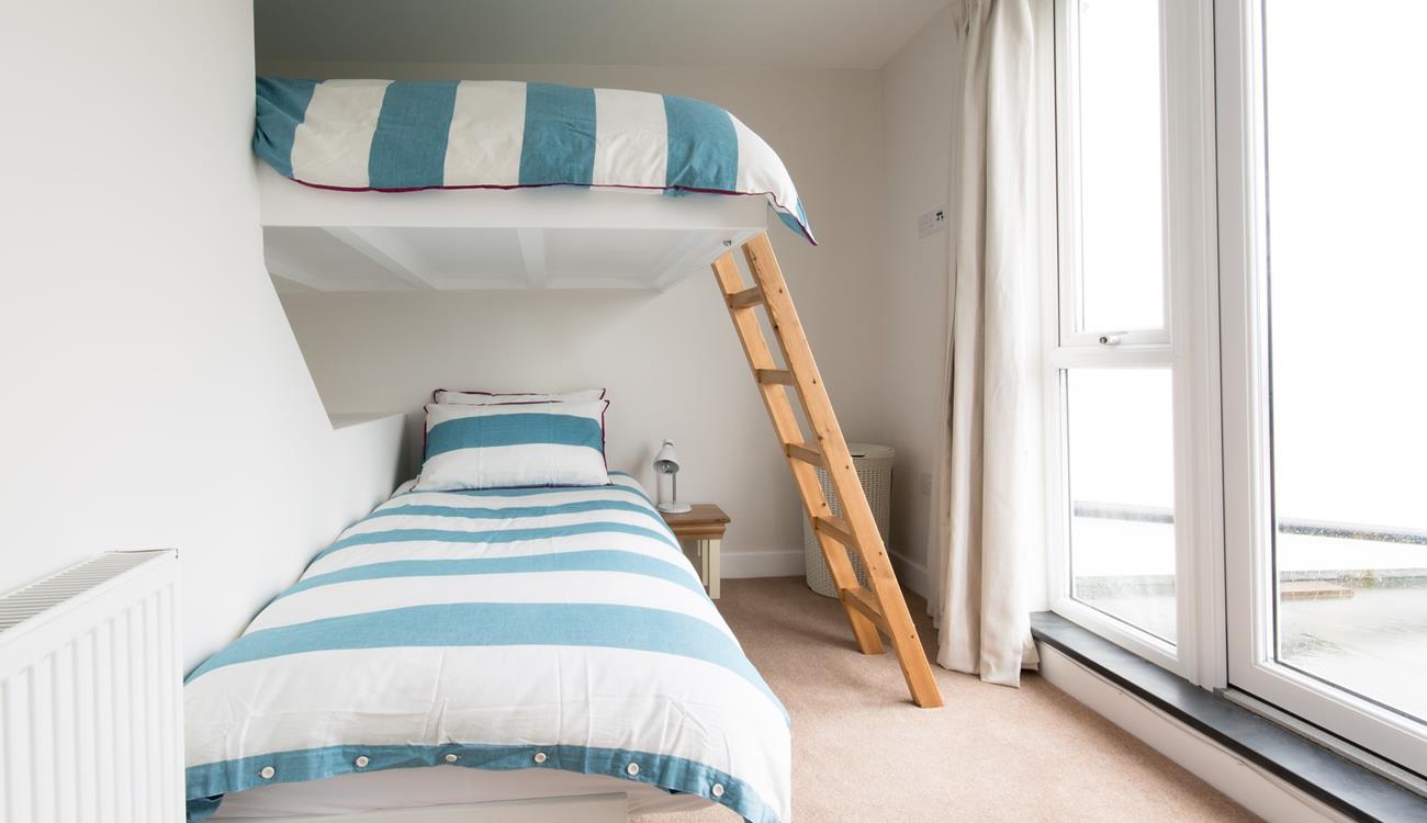 This cleverly-designed bedroom features a single bed below with a double bed above, integrated into the wall.