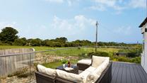 Relax on the large balcony, glass of wine in hand, overlooking the meadows and distant sea views. 