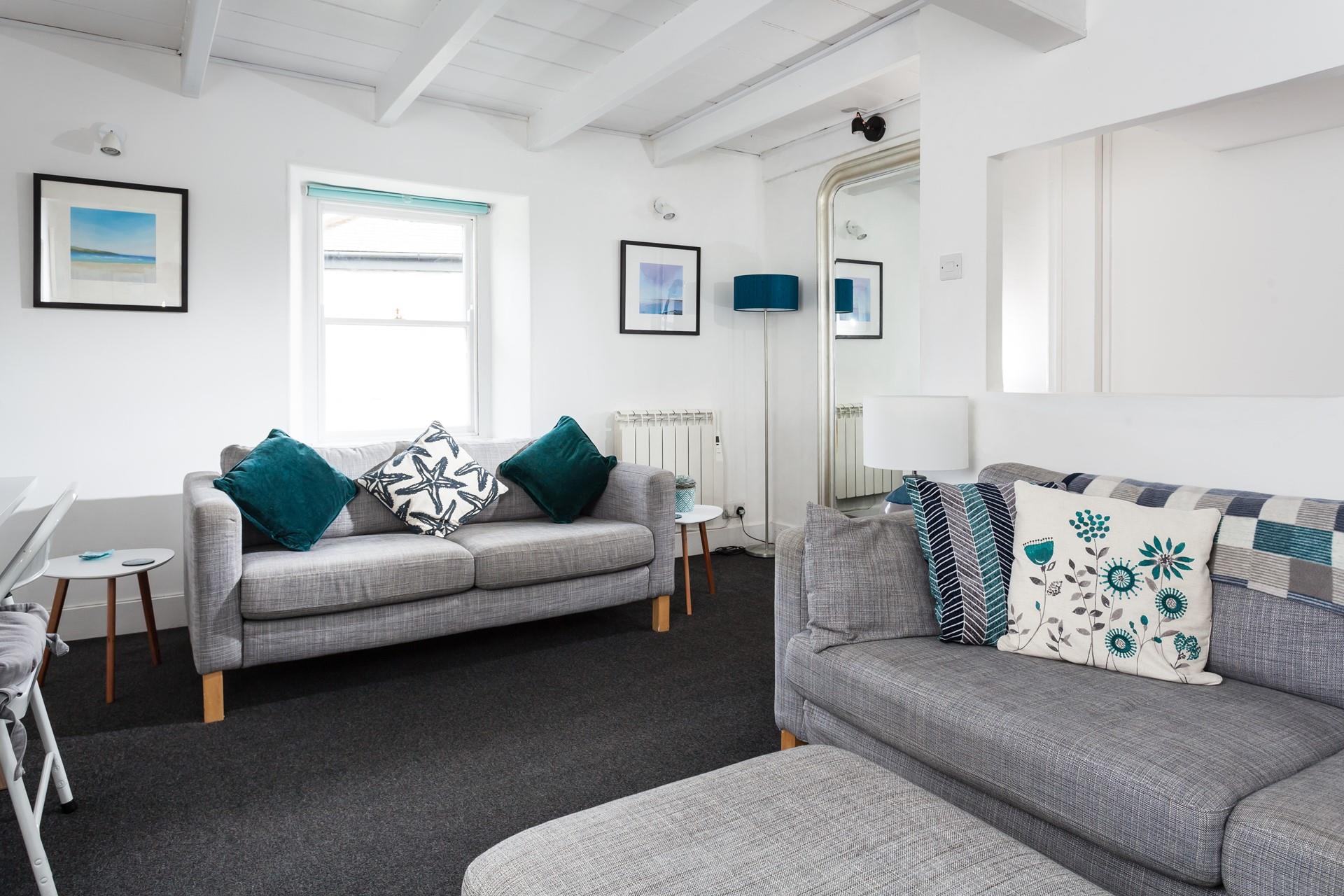 The sitting room has grey and deep green interiors creating a beautiful space to relax.