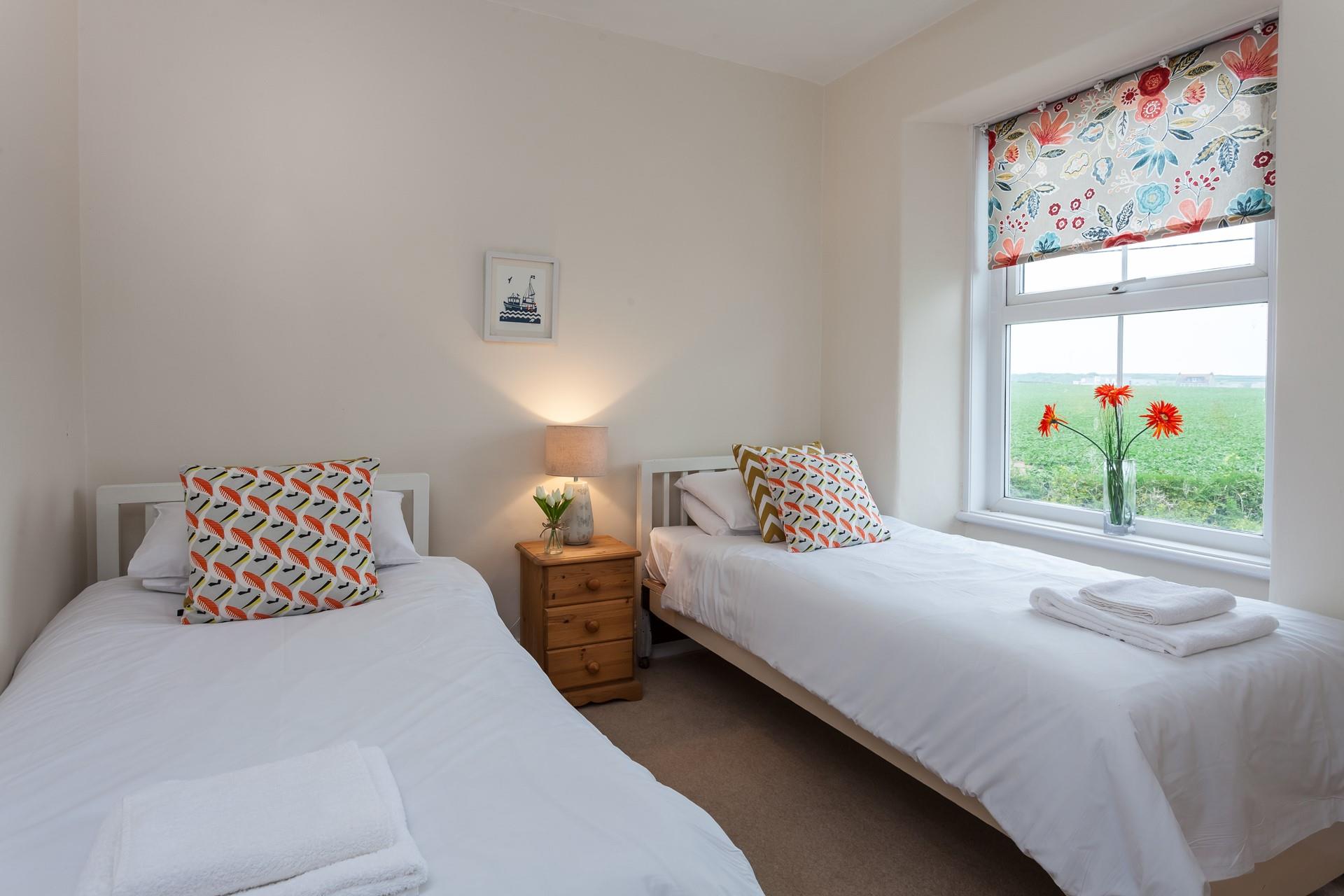 Pops of colour and a lovely, rural view in the twin bedroom.