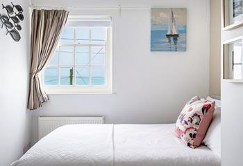 This comfortable and bright double bedroom has gorgeous sea views. 