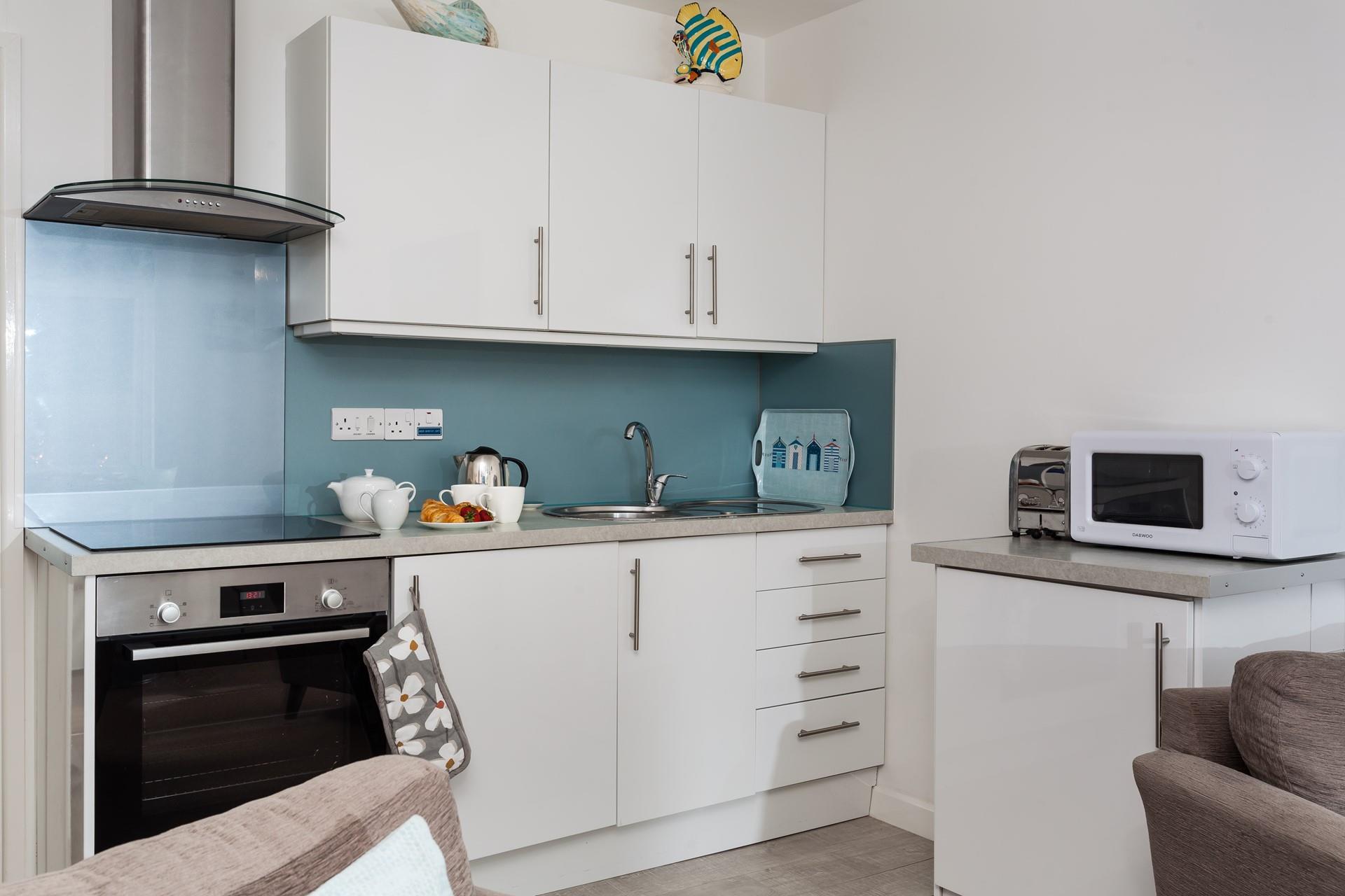 The kitchen is modern and well-equipped with a blue theme.