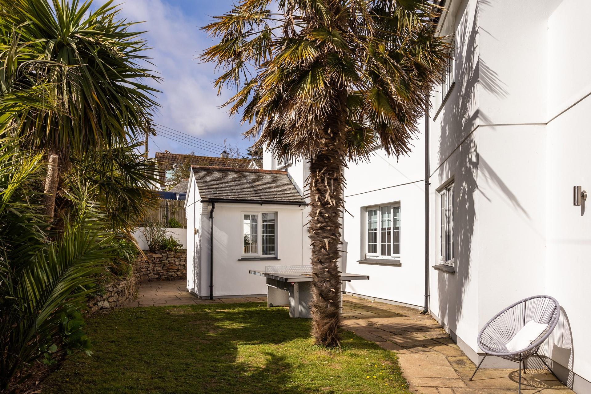 Leafy palms give the front garden a tropical feel. 