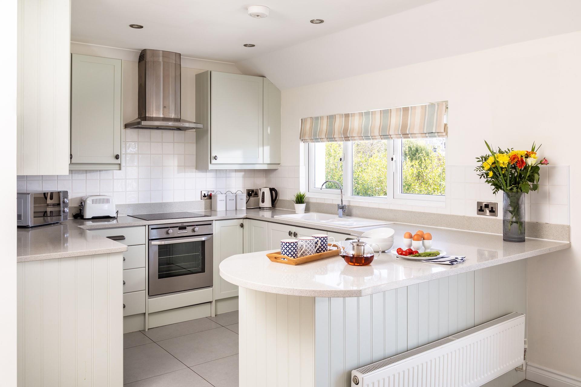 The kitchen is modern, sleek, and fully equipped, with a breakfast bar that's perfect for socialising. 