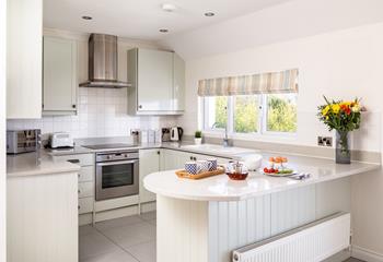 The kitchen is modern, sleek, and fully equipped, with a breakfast bar that's perfect for socialising. 