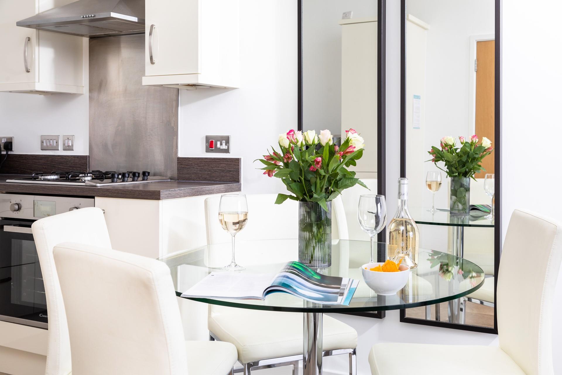 The stylish glass dining table and cream chairs make this the perfect little spot for unwinding with a glass in hand.