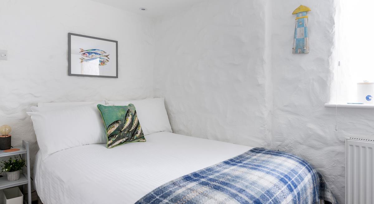The painted stone walls give the bedroom a quaint, cottage-like feel.