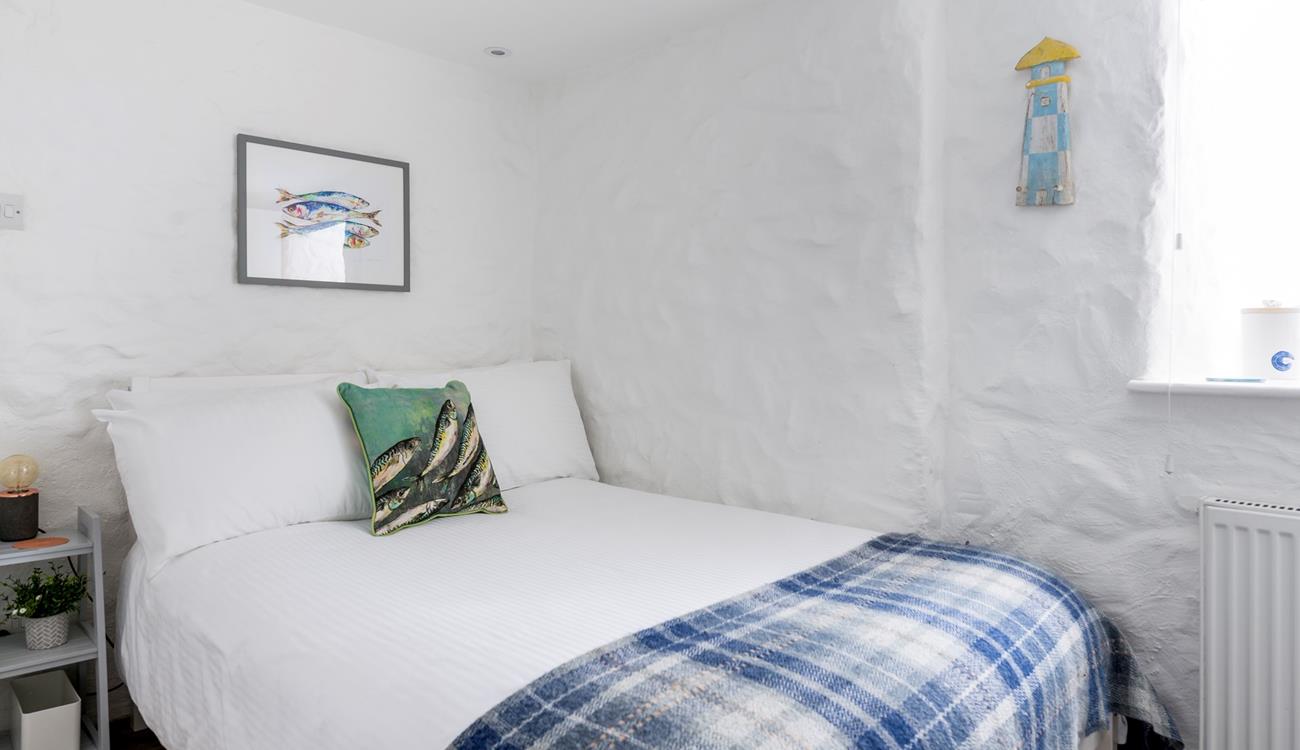 The painted stone walls give the bedroom a quaint, cottage-like feel.