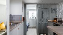 The semi-open wall allows light to stream through the entire studio apartment. 