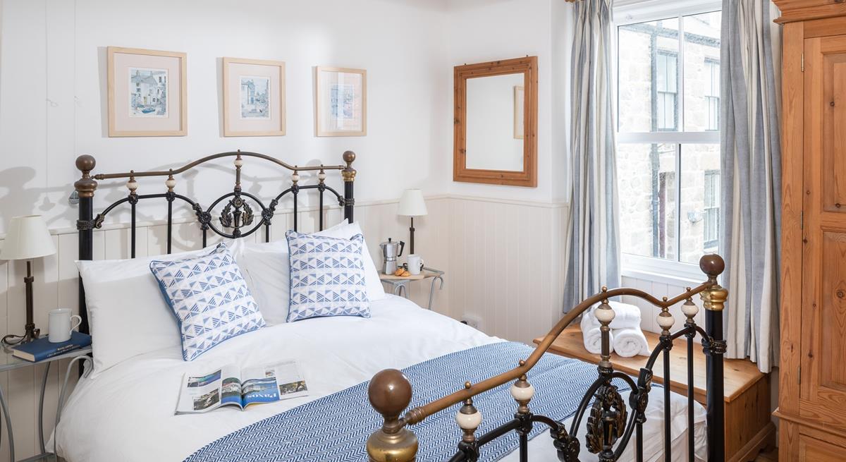 Classic furniture and a striking bed frame add a touch of luxury to the main bedroom.