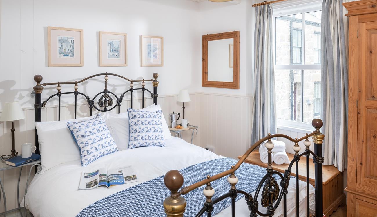 Classic furniture and a striking bed frame add a touch of luxury to the main bedroom.