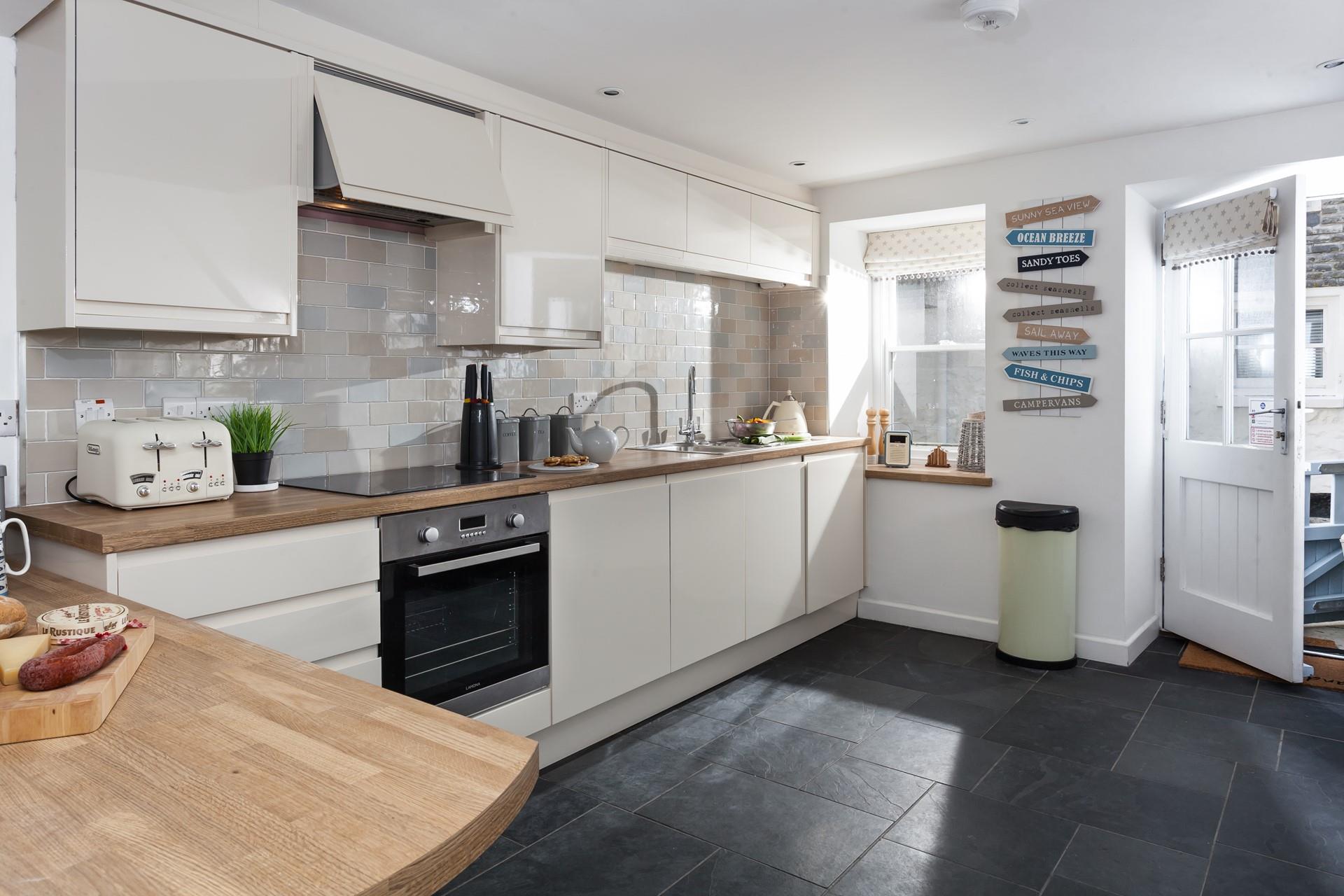 The kitchen is beautifully decorated in neutral tones and is fabulously well-equipped with modern appliances.