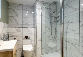 The shower room boasts a spacious walk-in, rainfall shower.