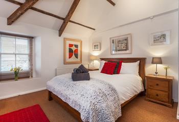 Exposed beams, a large bed and rich tones give the main bedroom a characterful and luxurious feel!