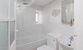 The modern bathroom is located on the first floor and boasts both a bath and a shower. - Thumbnail Image