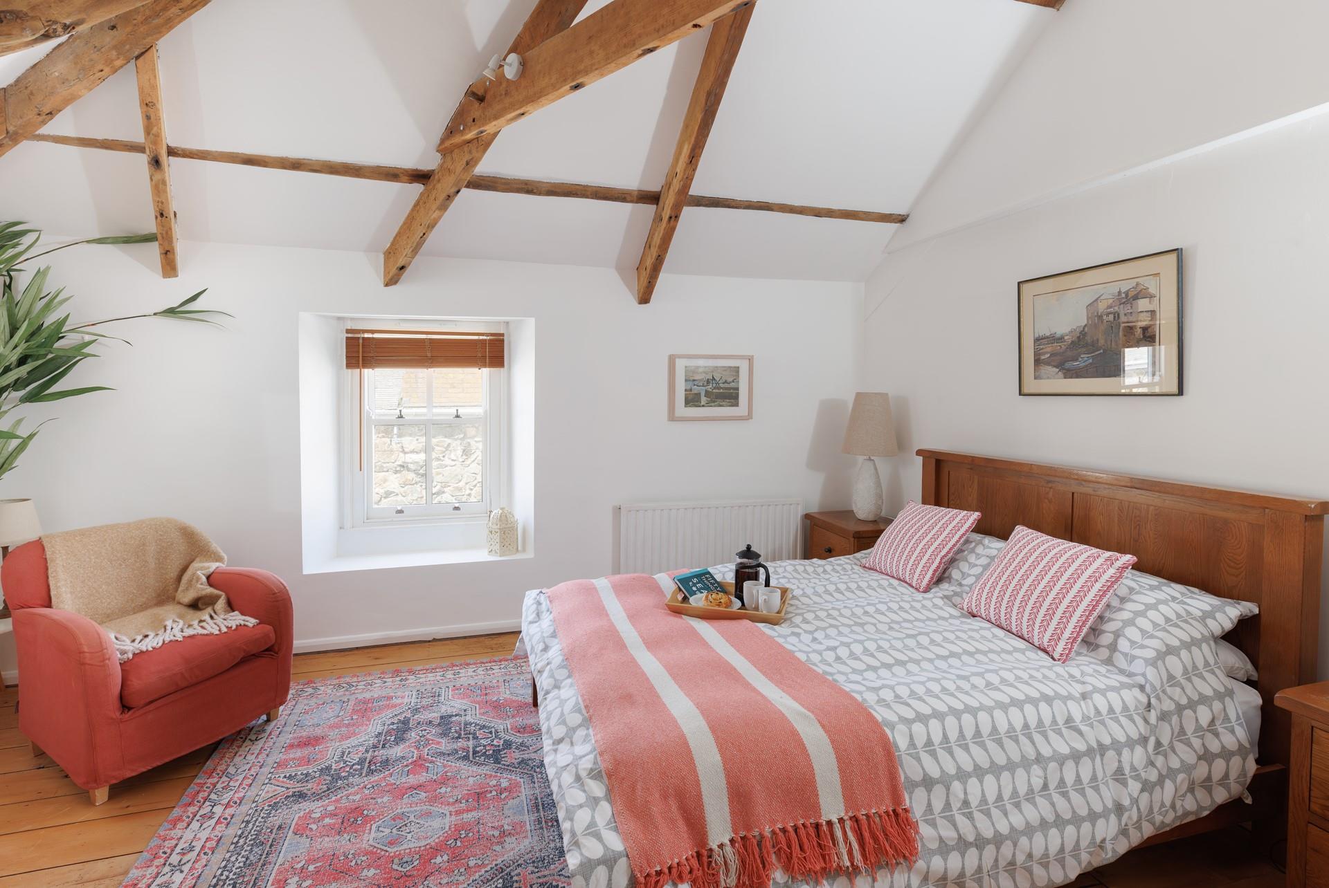 Exposed beams give the main bedroom a characterful and luxurious feel!