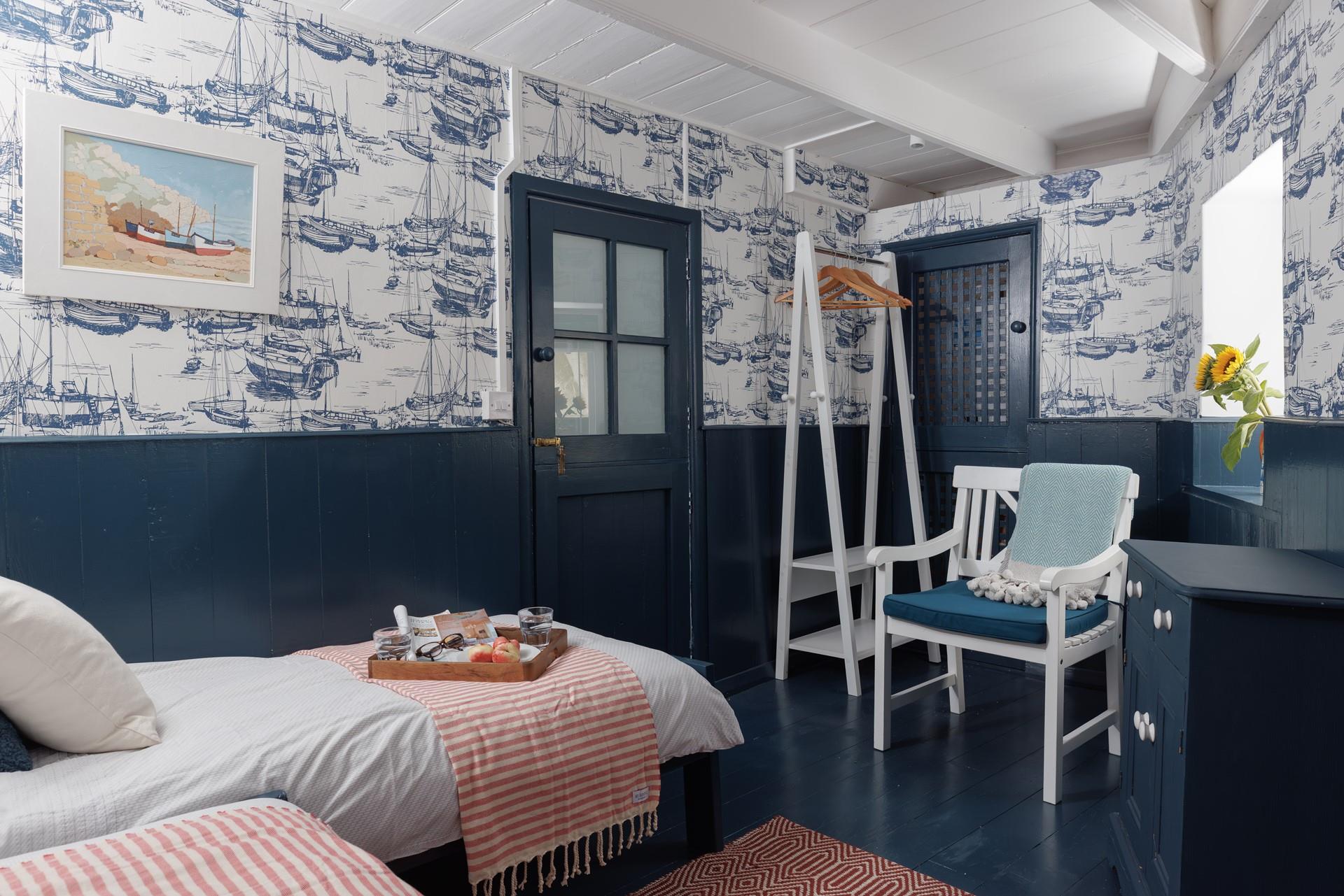 The twin room is decorated with fun nautical wallpaper.