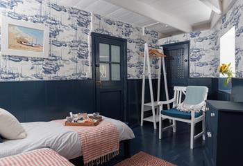 The twin room is decorated with fun nautical wallpaper.
